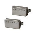 Pair of silver humbucker guitar pickups with exposed screw pole pieces and braided wire leads.