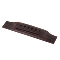 Dark brown wooden bridge for acoustic guitar with six holes for strings.