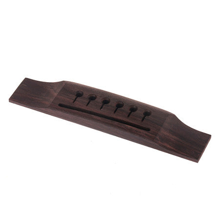 Dark brown wooden bridge for acoustic guitar with six holes for strings.