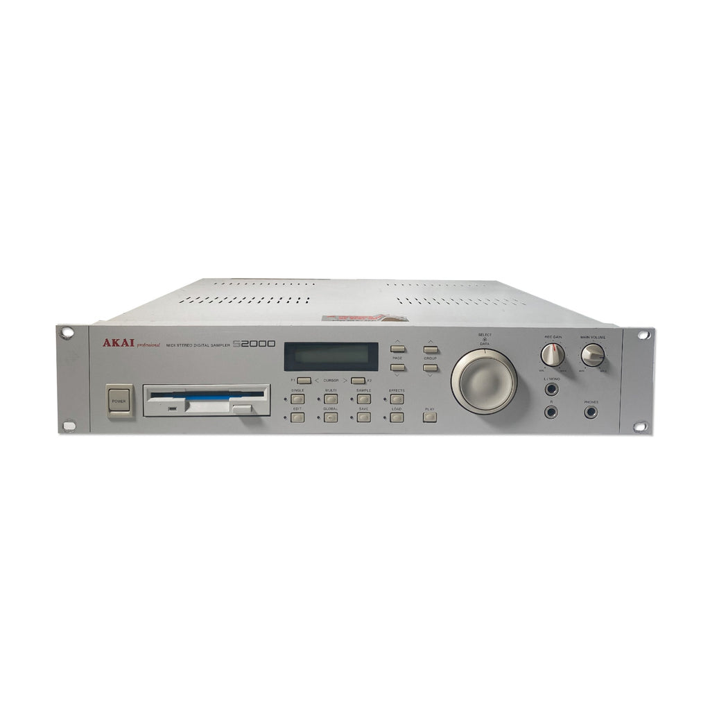 Front view of a gray rackmount digital sampler with buttons, screen, knobs, and audio jacks.