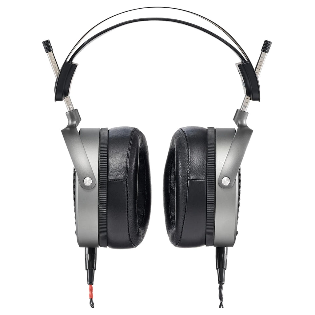 Front view of over-ear headphones with black cushioned ear pads and silver frame showing wired connectors.