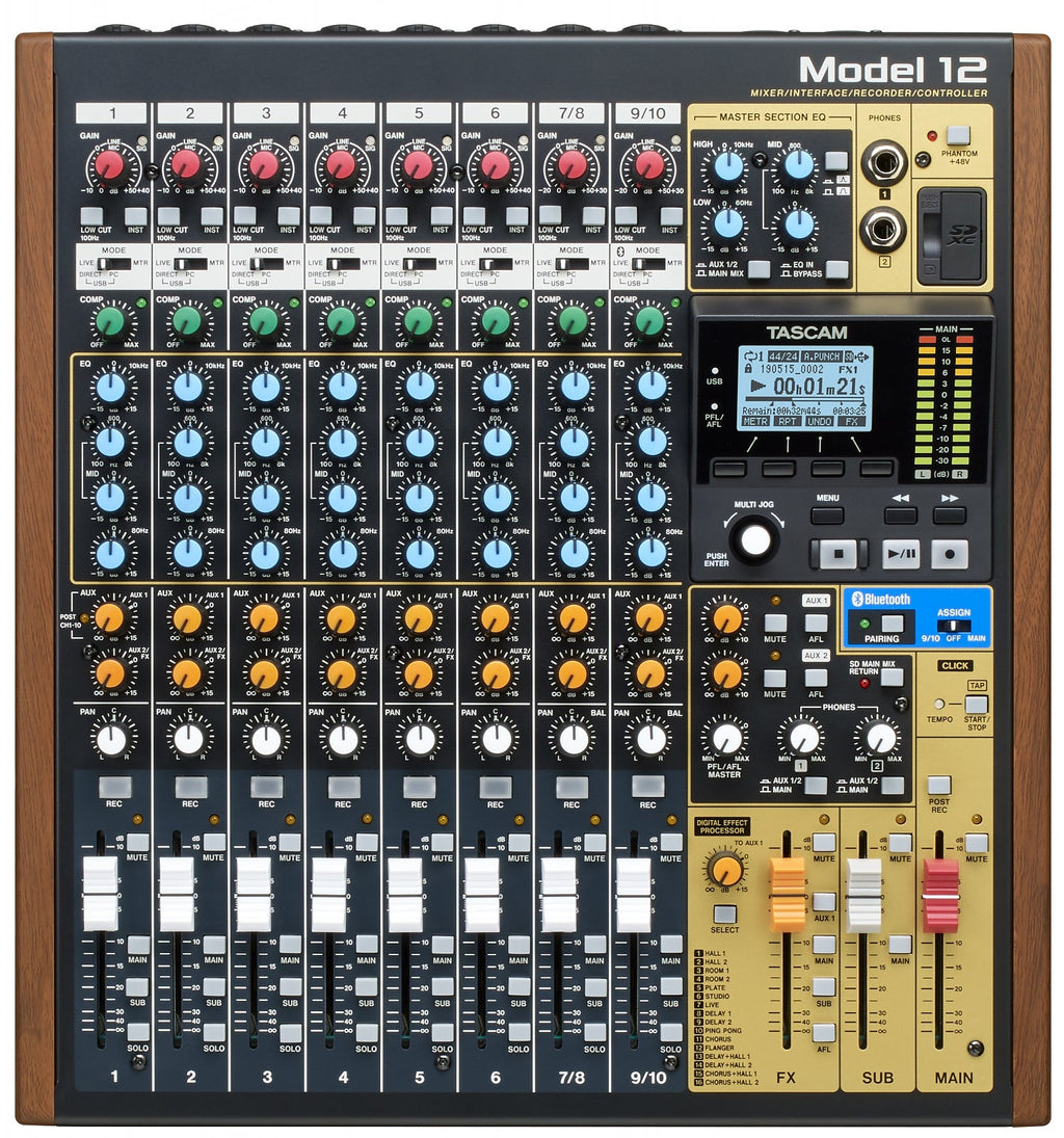 Top view of a Tascam Model 12 audio mixer with knobs, faders, buttons, headphone jacks, and an LCD screen.