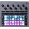 Top view of a gray Novation Circuit Rhythm music production device with knobs, buttons, and illuminated pads.