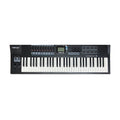 Black and white MIDI keyboard controller with keys, pads, faders, knobs, and a screen.