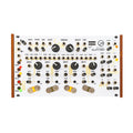 White modular synthesizer module with multiple knobs, switches, and patch cable jacks, wooden side panels.