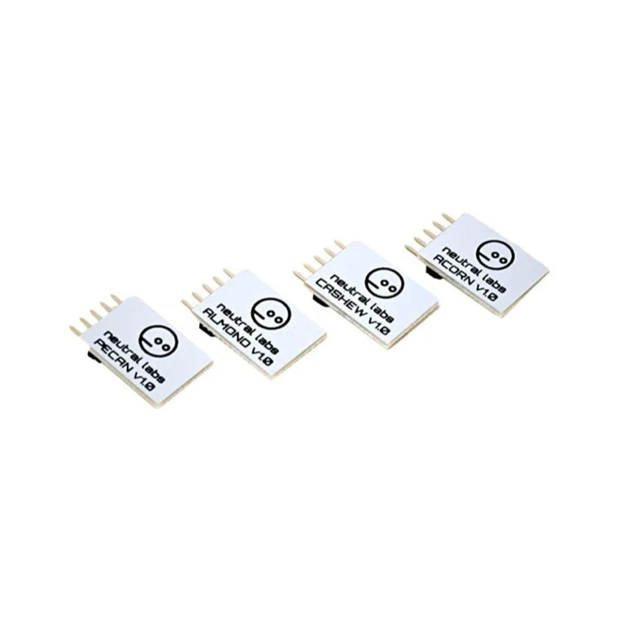 Four small white electronic modules labeled PECAN, ALMOND, CASHEW, and ACORN with pin connectors