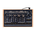 Top view of a black modular synthesizer with multiple sliders, knobs, jack inputs, and buttons in a wooden frame.