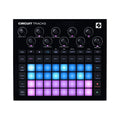 Top view of a black music production controller with knobs, buttons, and multicolored illuminated pads.