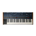 Top view of a black and wooden synthesizer keyboard with multiple knobs, buttons, sliders, and pitch/mod wheels.