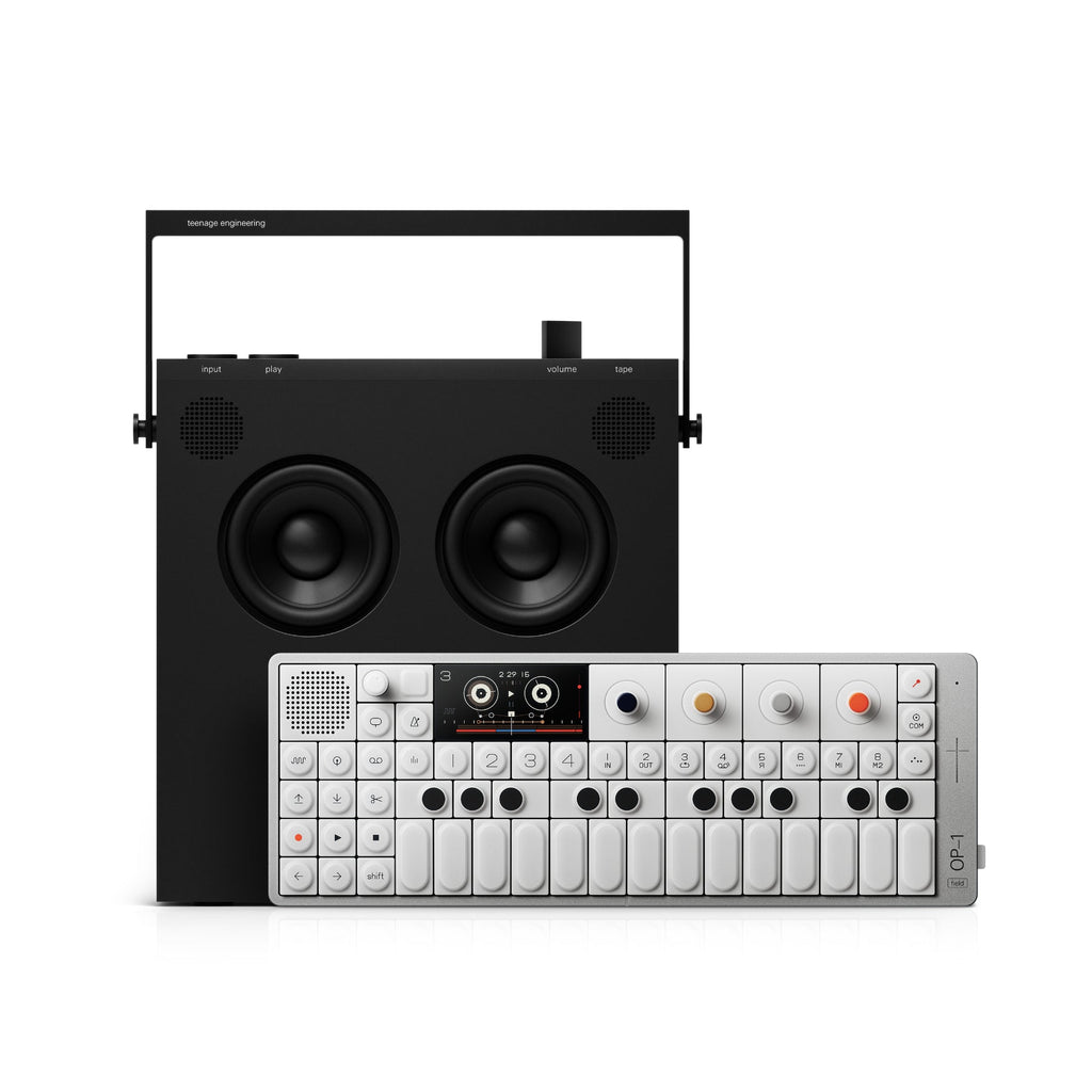 Black portable speaker with handle behind a compact white synthesizer keyboard with buttons and small display