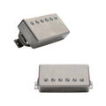 Two silver metal humbucker pickups with braided wire leads shown from two angles on a white background.