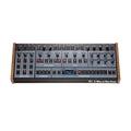 Front view of Oberheim synthesizer module with multiple knobs, buttons, and a small display screen.