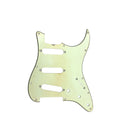 A worn pale yellow guitar pickguard with three pickup slots and 11 screw holes.