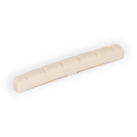 Off-white slotted guitar nut with several evenly spaced slots along its length.