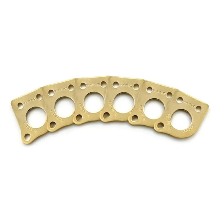 Six gold metal plates each with three holes, arranged in a curved line on a white background.