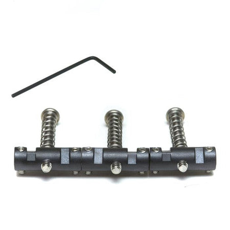 Set of three black metal barrel saddles for guitar bridge and an allen wrench on a white background.