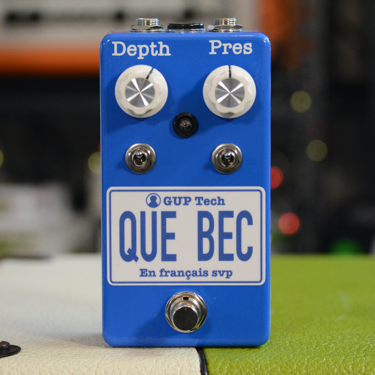 Blue guitar pedal with two white knobs labeled Depth and Pres, two toggle switches, and a footswitch.