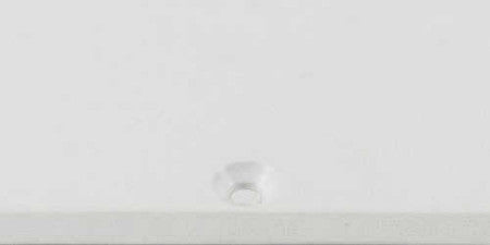 Blank white single-ply pickguard with screw hole on white surface.