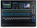 Top view of a black digital audio mixer with multiple faders, knobs, buttons, two screens, and labeled channels.