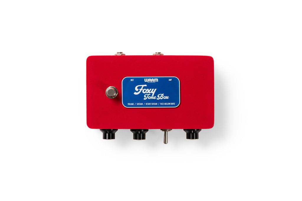 Red guitar effects pedal with three black knobs, a silver toggle switch, a footswitch, and a blue label named Foxy Tone Box.