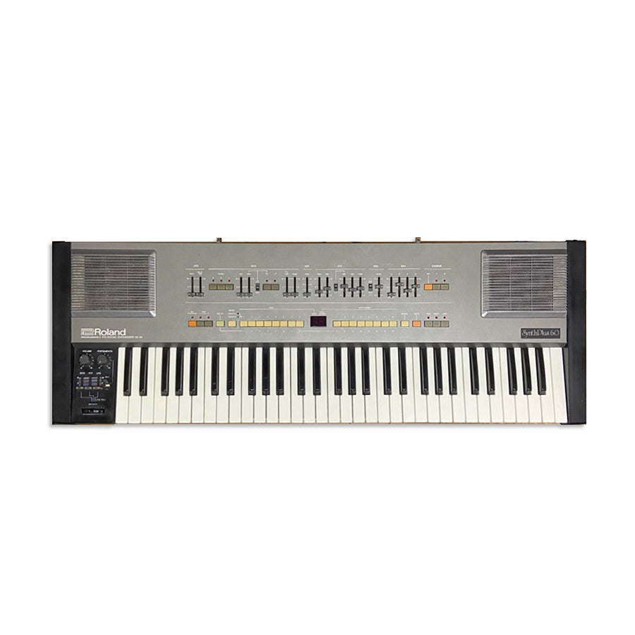 Top view of a vintage Roland Synth Plus 60 keyboard synthesizer with sliders, buttons, and speakers.