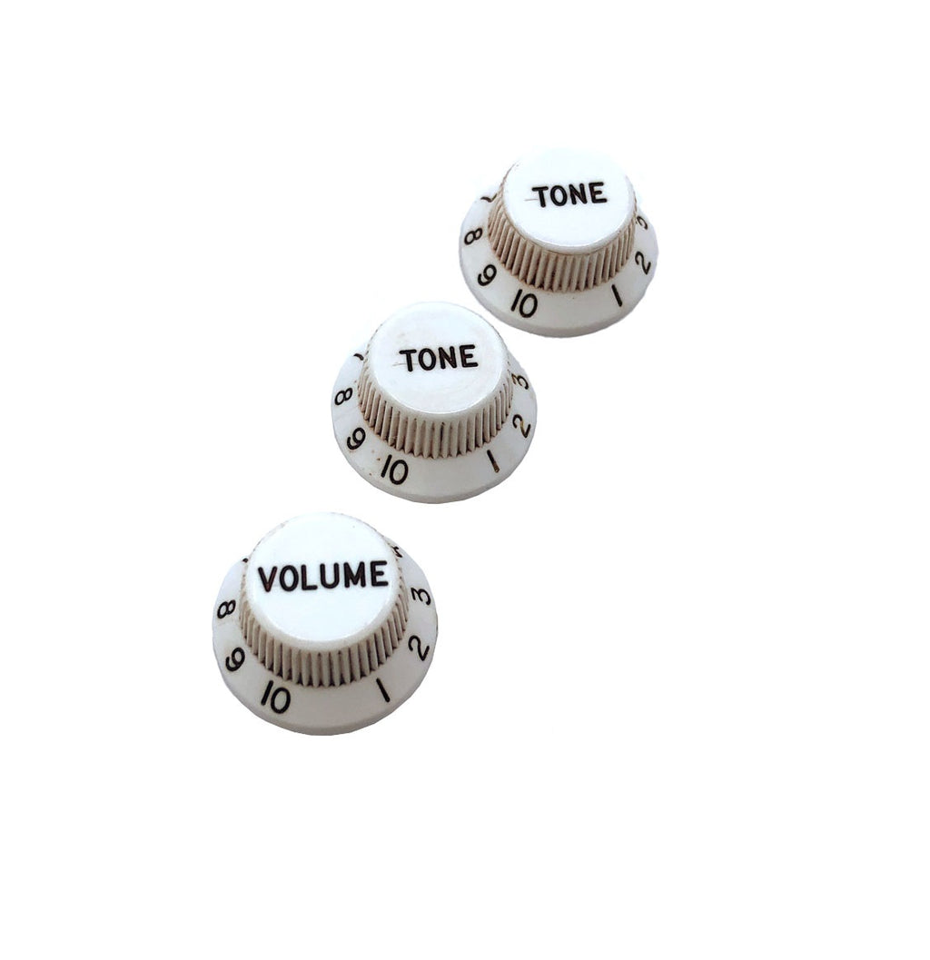 Three white control knobs with black numbering and lettering labeled TONE and VOLUME.