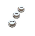Three white control knobs with black numbering and lettering labeled TONE and VOLUME.