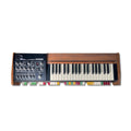 Vintage synthesizer keyboard with wooden side panels, knobs, faders, and colored switches below keys