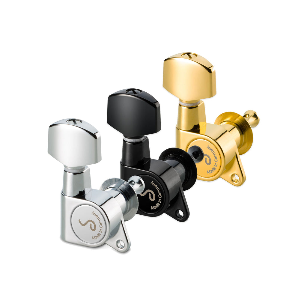 Three metal guitar tuning machine heads in silver, black, and gold finishes arranged in a row.