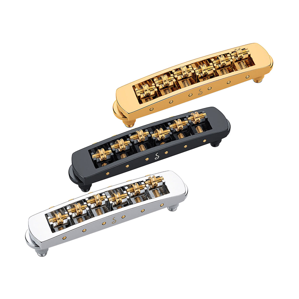 Three metallic guitar bridge units in gold, black, and silver with brass saddles and adjustment screws.
