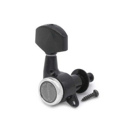 Black individual guitar tuner with silver ring and accompanying screw on white background.
