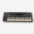 Black keyboard synthesizer with white and black keys and multiple sliders and buttons on top panel.