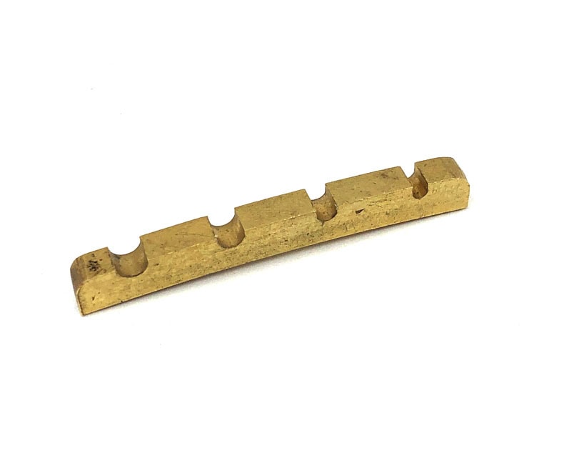 Pre-slotted brass guitar or bass nut with four string slots shown on a white background.