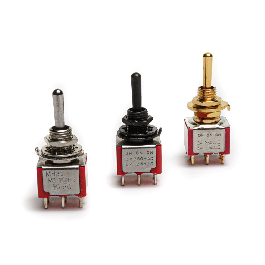 Three mini toggle switches with metal and plastic bodies, each having a different toggle lever color and six pin terminals.