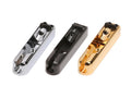 Three metal guitar bridge saddles in silver, black, and gold finishes are arranged side by side on a white background.