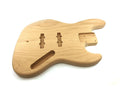 Unfinished natural wood bass guitar body with routed pickup and neck cavities on a white background.
