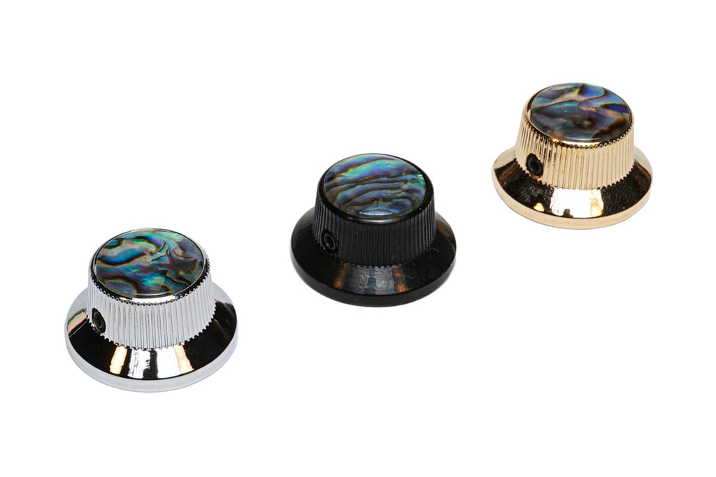 Three knurled knobs with abalone dome tops in silver, black, and gold finishes.