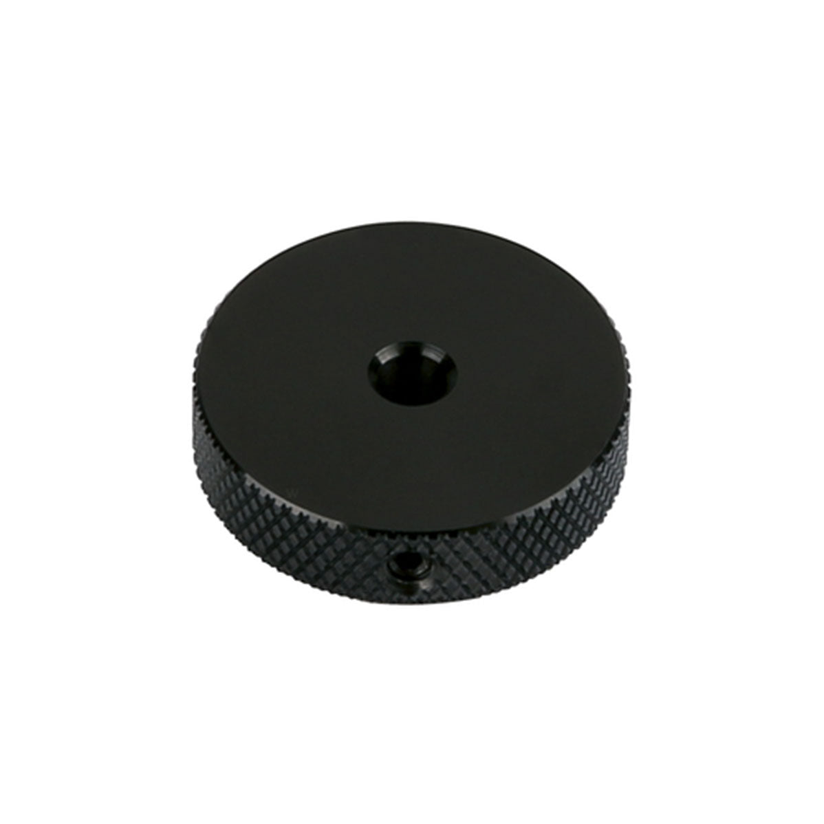 Black circular metal control knob with textured grip and a central hole.