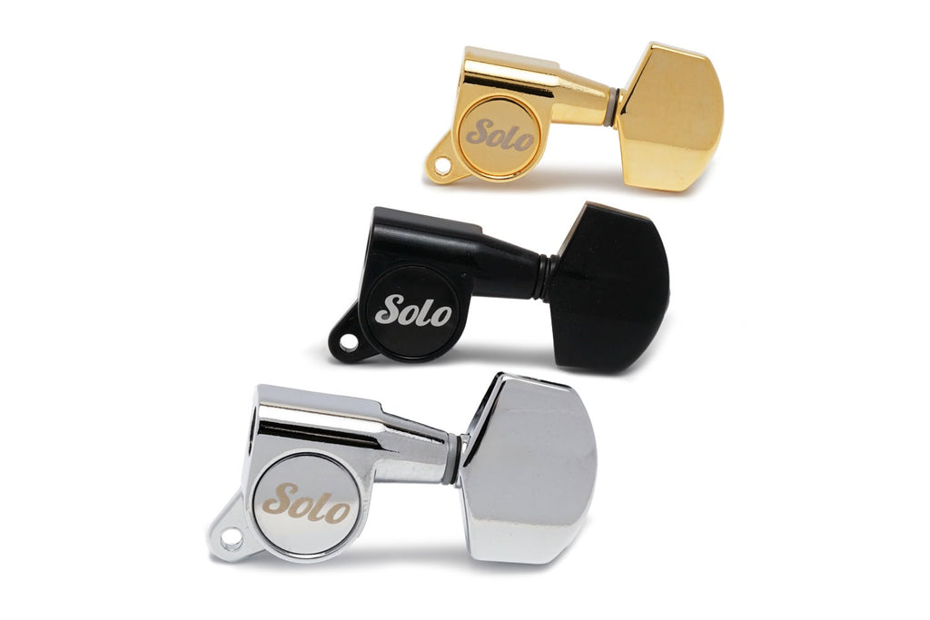Three guitar machine head tuners in gold, black, and silver colors with Solo branding on them.