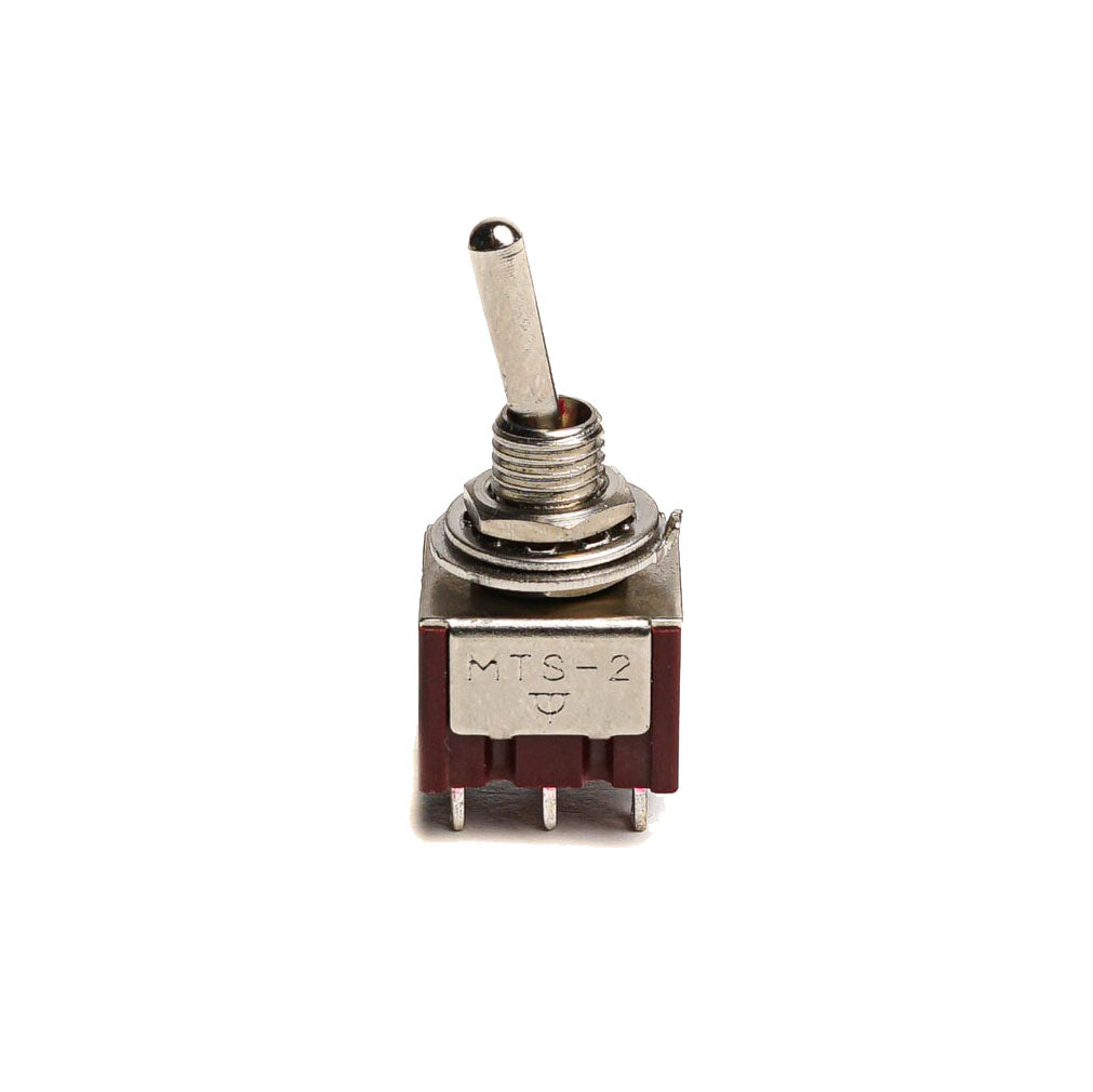 Metal toggle switch with six pin terminals and a brown plastic base shown front-facing on white background.