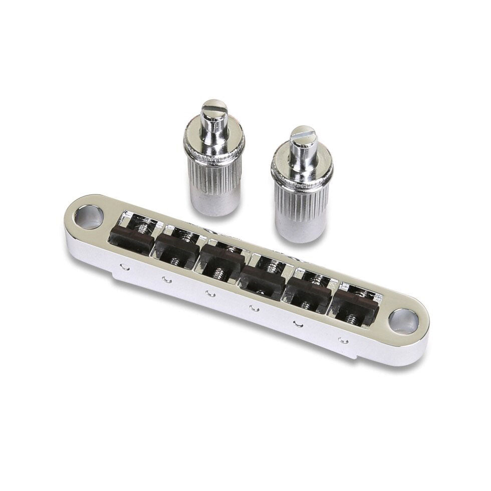 Silver tune-o-matic guitar bridge with black saddles and two large silver posts on a white background.