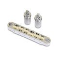 Silver metal guitar bridge with off-white nylon saddles and two matching large posts on a white background.
