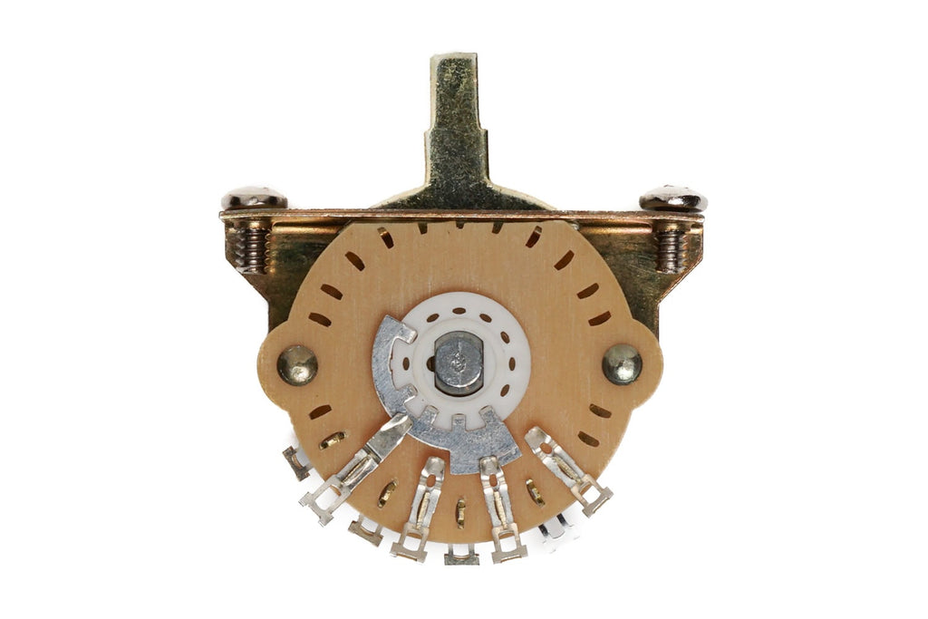 Beige circular lever switch with five metal terminal connectors and a gold mounting bracket viewed from the rear.
