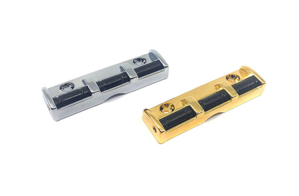 Two roller guitar nuts in silver and gold finish with black rollers and mounting holes.