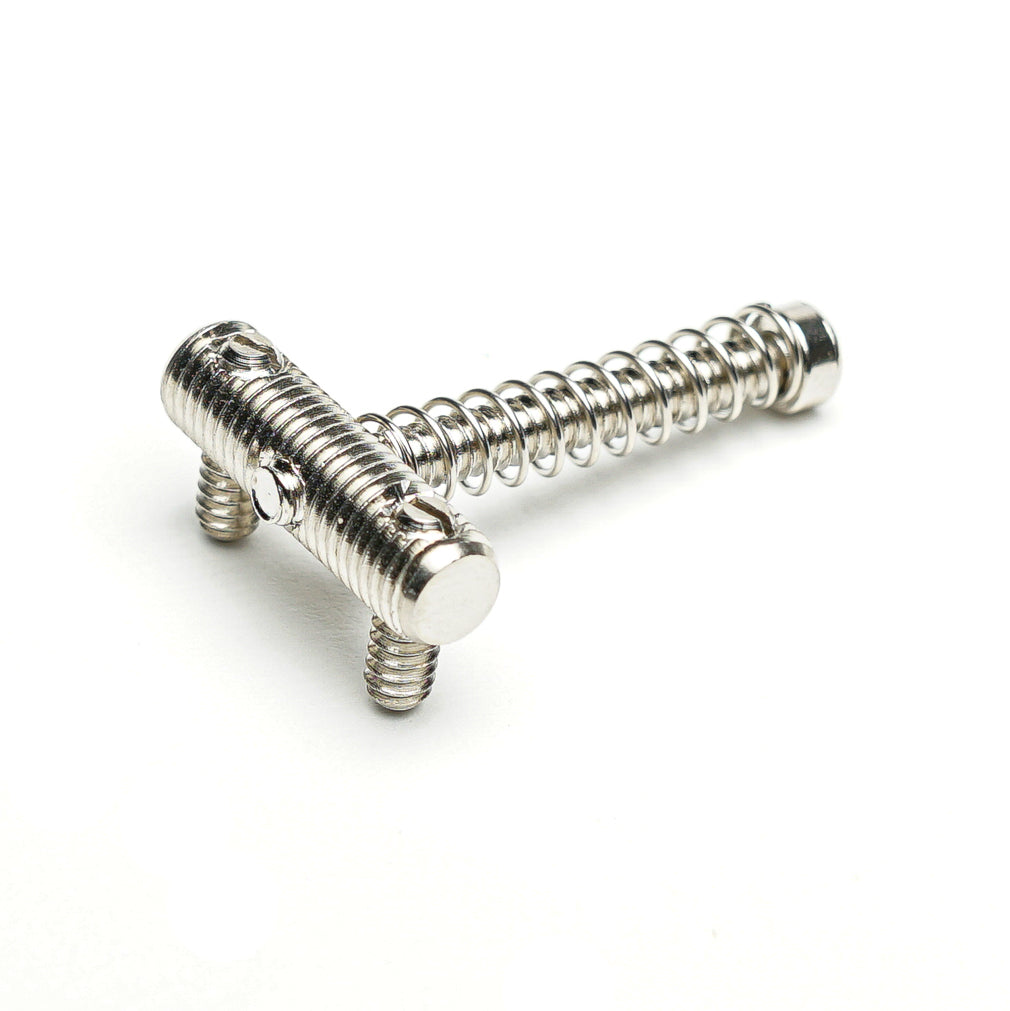 Metal guitar bridge saddle and spring assembly on a white background.