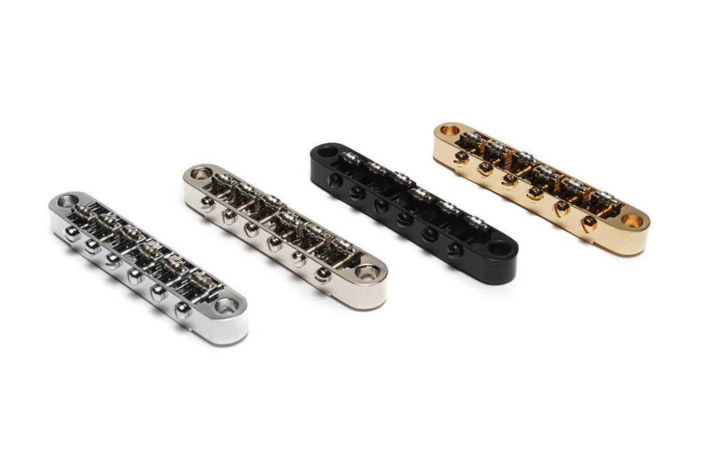 Four metal roller saddles arranged side by side in silver, nickel, black, and gold finishes on white background.