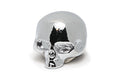 Shiny chrome skull-shaped metal knob with hollow eye sockets and nose, viewed from a slightly angled front side.