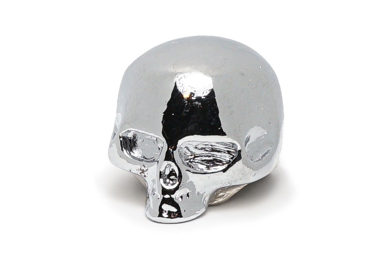 Shiny chrome skull-shaped metal knob with hollow eye sockets and nose, viewed from a slightly angled front side.