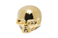 Close-up of a shiny gold-colored metal skull-shaped knob.