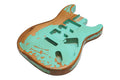 A guitar body with an aqua painted relic finish exposing wood underneath, showing pickups and control cavities.